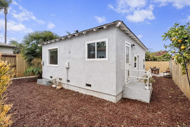 216466 S 40th St, San Diego, CA 92113 - view of side of property featuring a fenced backyard, stucco siding, and crawl space