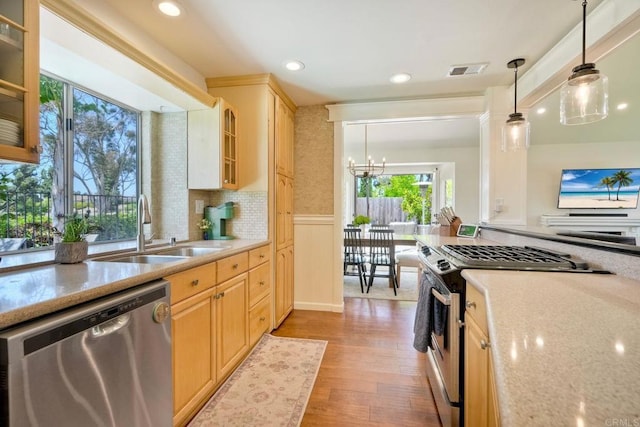 1675 Bronco Way, Oceanside, CA 92057 - kitchen with stainless steel appliances, light wood-style floors, a chandelier, light brown cabinetry, and a wainscoted wall