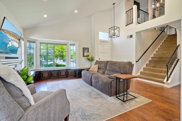 1675 Bronco Way, Oceanside, CA 92057 - living area featuring stairway, wood finished floors, a chandelier, high vaulted ceiling, and recessed lighting