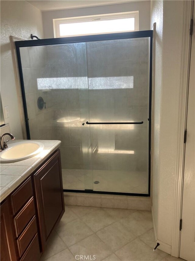 1830 Nevada St, Gridley, CA 95948 - full bath featuring vanity, a stall shower, plenty of natural light, and tile patterned flooring