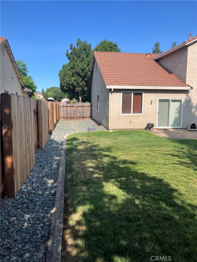 1830 Nevada St, Gridley, CA 95948 - rear view of house featuring stucco siding, a fenced backyard, and a tiled roof