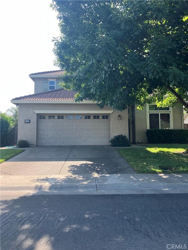1830 Nevada St, Gridley, CA 95948 - view of front facade featuring stucco siding, an attached garage, driveway, and a tiled roof