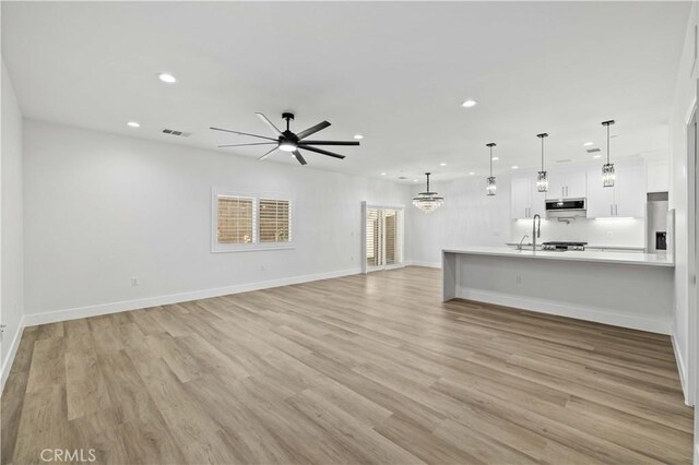 3838 Balmont St, Lancaster, CA 93536 - unfurnished living room featuring recessed lighting, ceiling fan, light wood finished floors, and a chandelier