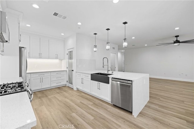 3838 Balmont St, Lancaster, CA 93536 - kitchen featuring stainless steel appliances, a peninsula, recessed lighting, light wood-style floors, and white cabinetry