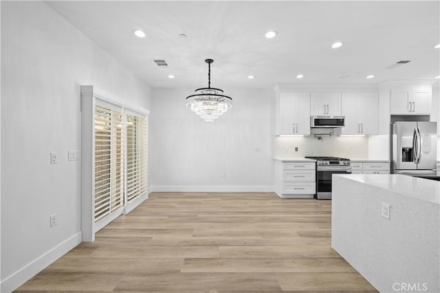 3838 Balmont St, Lancaster, CA 93536 - kitchen with stainless steel appliances, recessed lighting, white cabinets, light countertops, and a chandelier