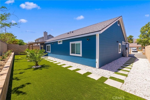 3838 Balmont St, Lancaster, CA 93536 - back of house featuring a fenced backyard, roof with shingles, and a chimney