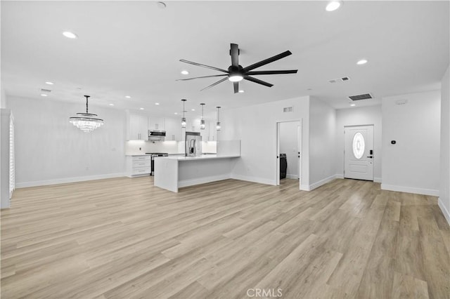 3838 Balmont St, Lancaster, CA 93536 - unfurnished living room with recessed lighting, a ceiling fan, light wood-style flooring, and a chandelier