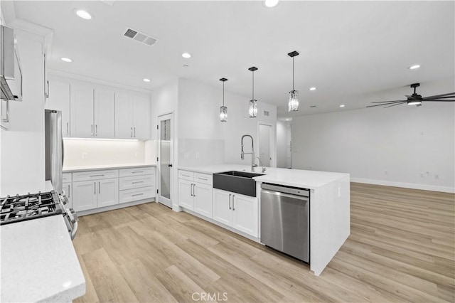 3838 Balmont St, Lancaster, CA 93536 - kitchen with stainless steel appliances, a peninsula, recessed lighting, light wood-style flooring, and white cabinetry