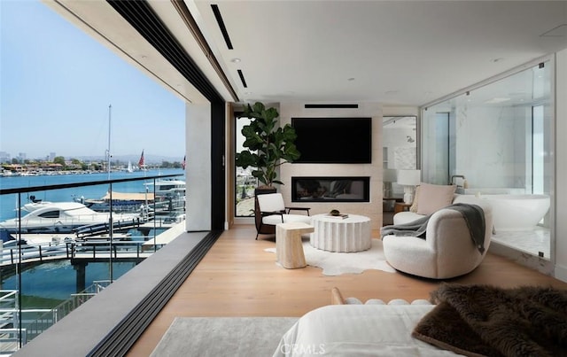642 Via Lido Nord, Newport Beach, CA 92663 - living room featuring a wall of windows, wood finished floors, a fireplace, and a water view