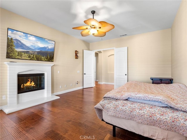 7219 Evening Star Rose Ct, Oak Hills, CA 92344 - bedroom featuring wood finished floors, a glass covered fireplace, and a ceiling fan