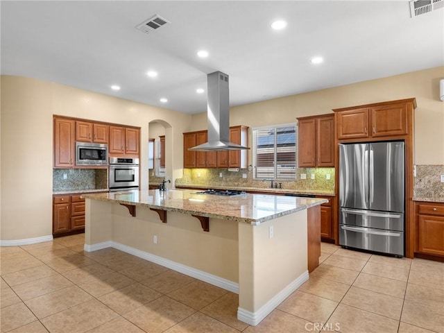 7219 Evening Star Rose Ct, Oak Hills, CA 92344 - kitchen featuring stainless steel appliances, ventilation hood, brown cabinets, backsplash, and recessed lighting