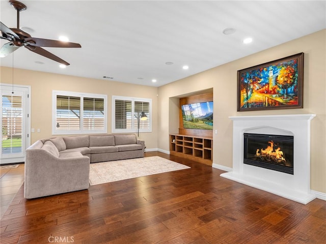 7219 Evening Star Rose Ct, Oak Hills, CA 92344 - living area featuring a glass covered fireplace, ceiling fan, wood finished floors, and recessed lighting