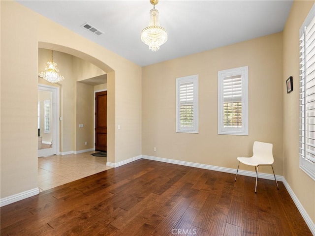 7219 Evening Star Rose Ct, Oak Hills, CA 92344 - unfurnished room with a chandelier, arched walkways, and healthy amount of natural light