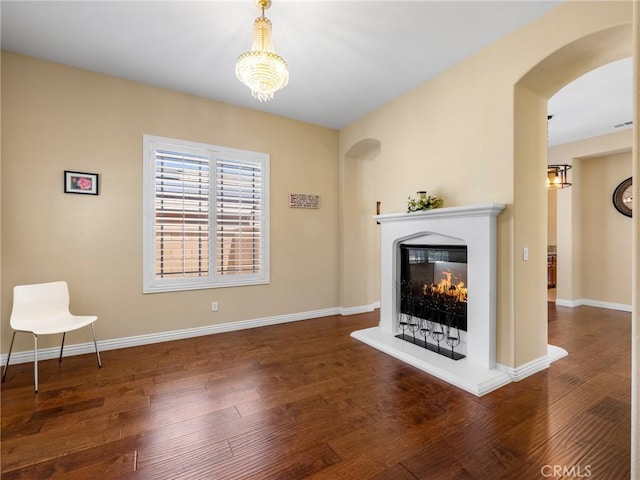 7219 Evening Star Rose Ct, Oak Hills, CA 92344 - unfurnished living room with arched walkways, wood finished floors, and a lit fireplace