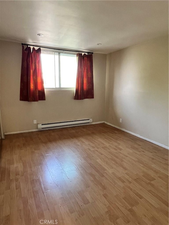 525 N Sycamore Ave Unit 304, Los Angeles, CA 90036 - spare room featuring a baseboard heating unit and wood finished floors