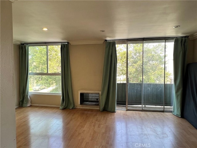 525 N Sycamore Ave Unit 304, Los Angeles, CA 90036 - empty room featuring heating unit, hardwood / wood-style floors, ornamental molding, a wall of windows, and recessed lighting