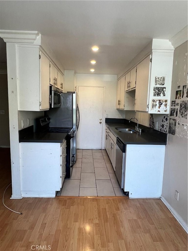 525 N Sycamore Ave Unit 304, Los Angeles, CA 90036 - kitchen featuring stainless steel appliances, dark countertops, light wood-type flooring, white cabinets, and recessed lighting