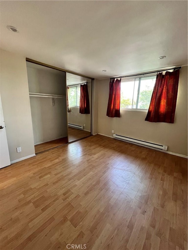 525 N Sycamore Ave Unit 304, Los Angeles, CA 90036 - unfurnished bedroom with a baseboard radiator and wood finished floors