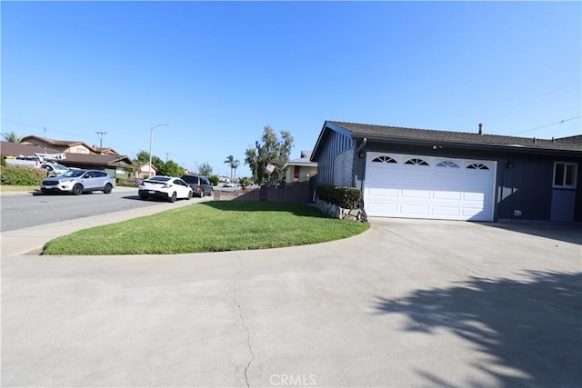 5519 Stevely Ave, Lakewood, CA 90713 - view of side of property with board and batten siding, a yard, and a garage