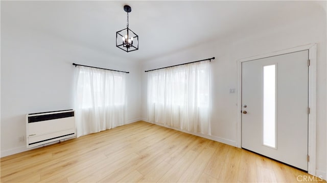 1113 Pacific Ave, Long Beach, CA 90813 - foyer entrance featuring heating unit, plenty of natural light, a chandelier, and wood finished floors