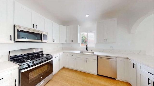 1113 Pacific Ave, Long Beach, CA 90813 - kitchen featuring stainless steel appliances, white cabinetry, light wood-type flooring, recessed lighting, and light stone counters