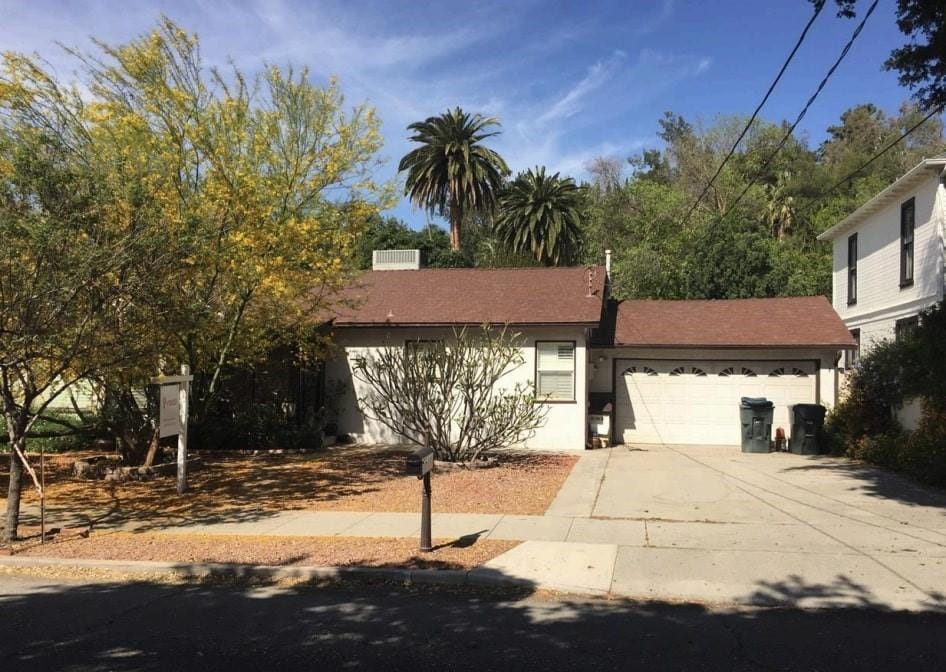 3376 N G St, San Bernardino, CA 92405 - view of front of house featuring a garage, driveway, stucco siding, and a shingled roof