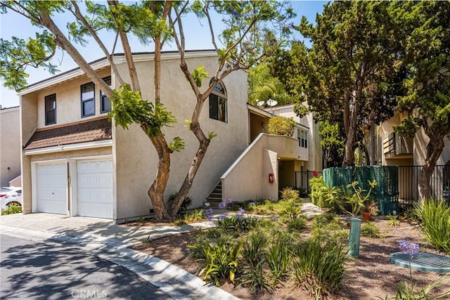 400 Brighton Spgs, Costa Mesa, CA 92627 - townhome / multi-family property featuring a garage, stucco siding, driveway, and stairs
