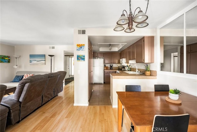 400 Brighton Spgs, Costa Mesa, CA 92627 - kitchen featuring freestanding refrigerator, open floor plan, light wood-style floors, a peninsula, and a chandelier