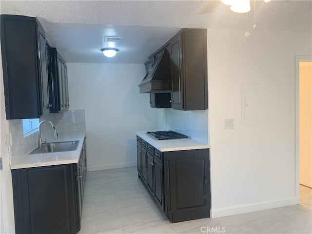 14299 La Paz Dr Unit 6, Victorville, CA 92395 - kitchen with custom exhaust hood, stainless steel gas stovetop, light countertops, electric panel, and a ceiling fan