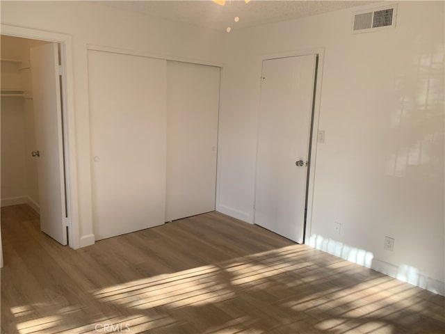 14299 La Paz Dr Unit 6, Victorville, CA 92395 - unfurnished bedroom featuring wood finished floors and a closet