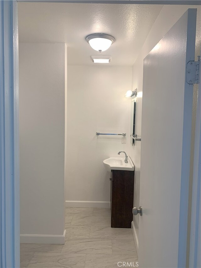 14299 La Paz Dr Unit 6, Victorville, CA 92395 - bathroom featuring vanity and marble look tile flooring