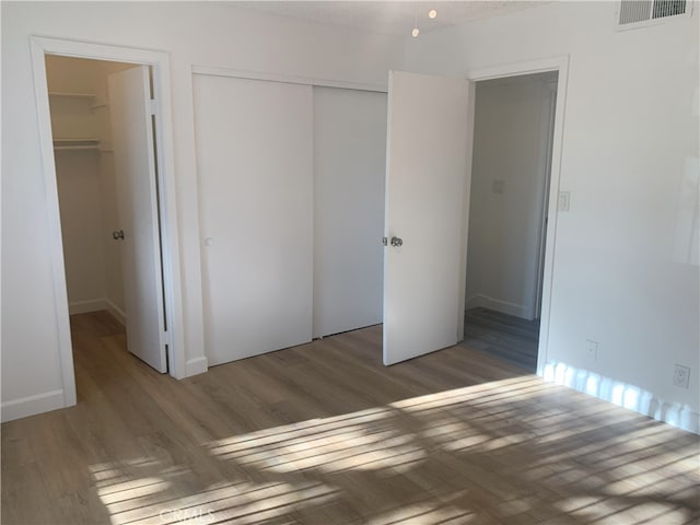 14299 La Paz Dr Unit 6, Victorville, CA 92395 - unfurnished bedroom with wood finished floors and a closet