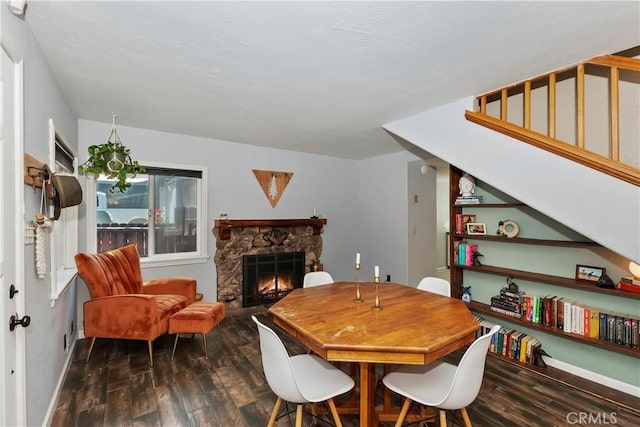 22989 Pine Ln, Crestline, CA 92325 - dining area with dark wood-style flooring, a stone fireplace, and stairway