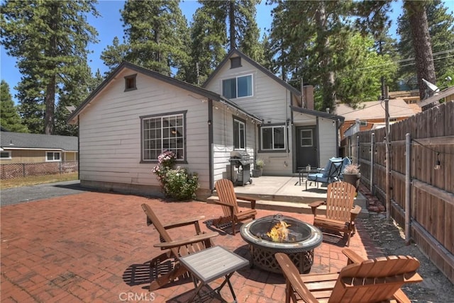 22989 Pine Ln, Crestline, CA 92325 - back of house featuring a fire pit, a patio area, and a fenced backyard