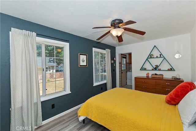 22989 Pine Ln, Crestline, CA 92325 - bedroom with wood finished floors, multiple windows, washer / clothes dryer, and a ceiling fan