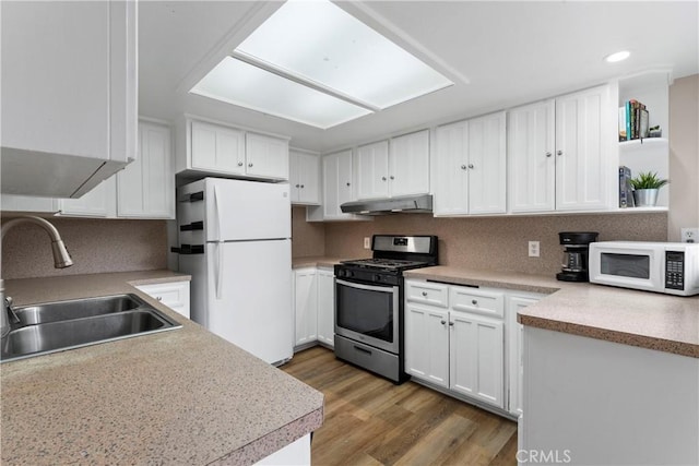 29289 Lake View Dr, Cedar Glen, CA 92321 - kitchen with white appliances, under cabinet range hood, white cabinetry, light countertops, and recessed lighting