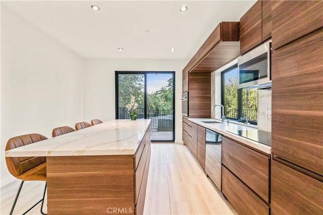 2315 Loma Vista Pl, Los Angeles, CA 90039 - kitchen with a breakfast bar area, stainless steel appliances, a center island, light wood-style flooring, and recessed lighting