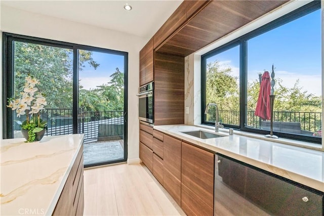 2315 Loma Vista Pl, Los Angeles, CA 90039 - kitchen featuring stainless steel appliances, light stone counters, modern cabinets, light wood finished floors, and recessed lighting