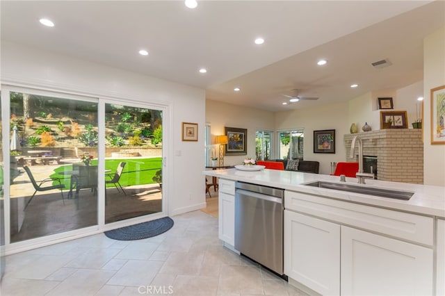 15535 Mallory Ct, Moorpark, CA 93021 - kitchen with stainless steel dishwasher, a brick fireplace, light countertops, white cabinets, and recessed lighting