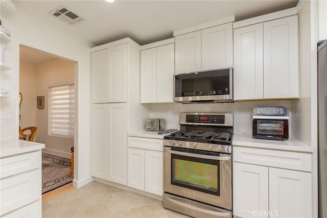 15535 Mallory Ct, Moorpark, CA 93021 - kitchen with stainless steel appliances, light countertops, white cabinets, and light tile patterned flooring