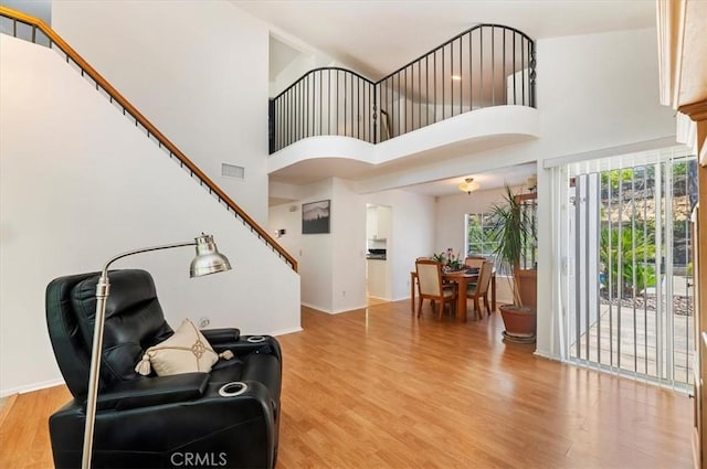 44938 Tehachapi, Temecula, CA 92592 - living room with light wood-style flooring, a high ceiling, and stairway