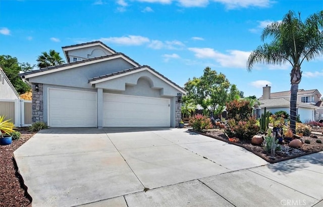44938 Tehachapi, Temecula, CA 92592 - view of front of house with concrete driveway, an attached garage, stucco siding, and stone siding