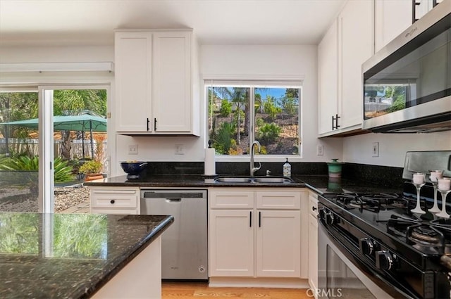 44938 Tehachapi, Temecula, CA 92592 - kitchen featuring appliances with stainless steel finishes, dark stone counters, white cabinets, and light wood-type flooring