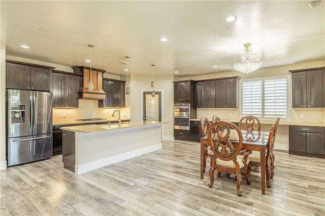 4664 Quartz Hill Rd, Quartz Hill, CA 93536 - kitchen with appliances with stainless steel finishes, custom exhaust hood, dark brown cabinets, a chandelier, and recessed lighting