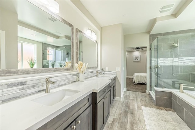 4664 Quartz Hill Rd, Quartz Hill, CA 93536 - bathroom featuring double vanity, a shower stall, a bath, wood finished floors, and decorative backsplash