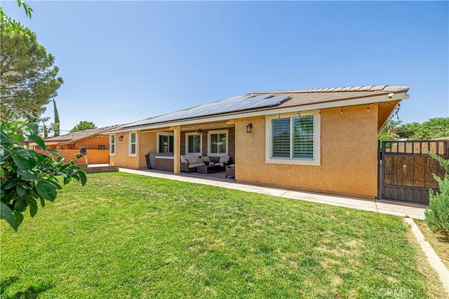 4664 Quartz Hill Rd, Quartz Hill, CA 93536 - rear view of house featuring an outdoor living space, roof mounted solar panels, stucco siding, a patio area, and a gate