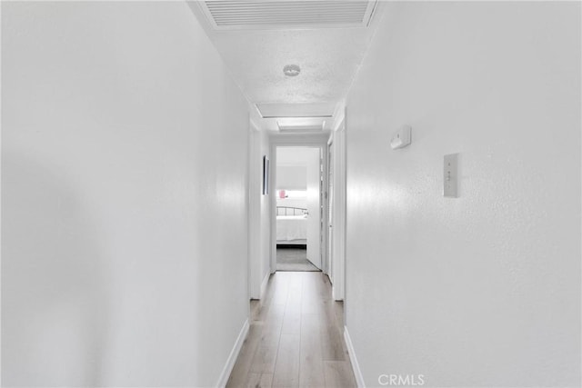 15761 Joshua Rd, Apple Valley, CA 92307 - hall featuring attic access, light wood-type flooring, and a textured ceiling