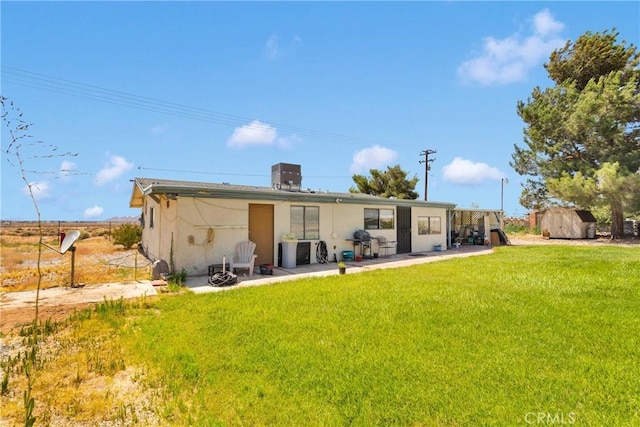 15761 Joshua Rd, Apple Valley, CA 92307 - back of property featuring a storage shed, a yard, a patio, and stucco siding