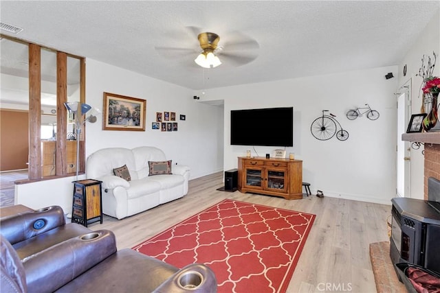 15761 Joshua Rd, Apple Valley, CA 92307 - living area with ceiling fan, wood finished floors, a textured ceiling, and a wood stove