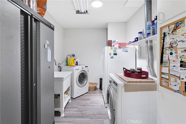 15761 Joshua Rd, Apple Valley, CA 92307 - laundry area featuring independent washer and dryer and light wood-type flooring